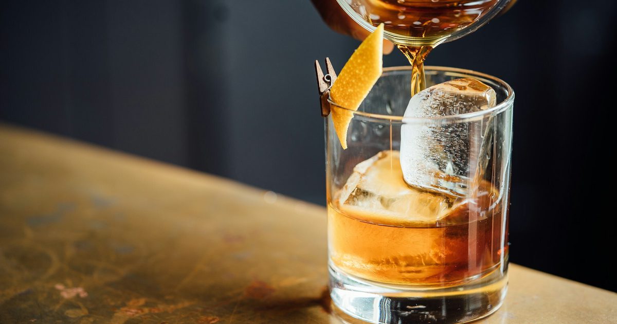 Close up of pouring a whisky drink with ice