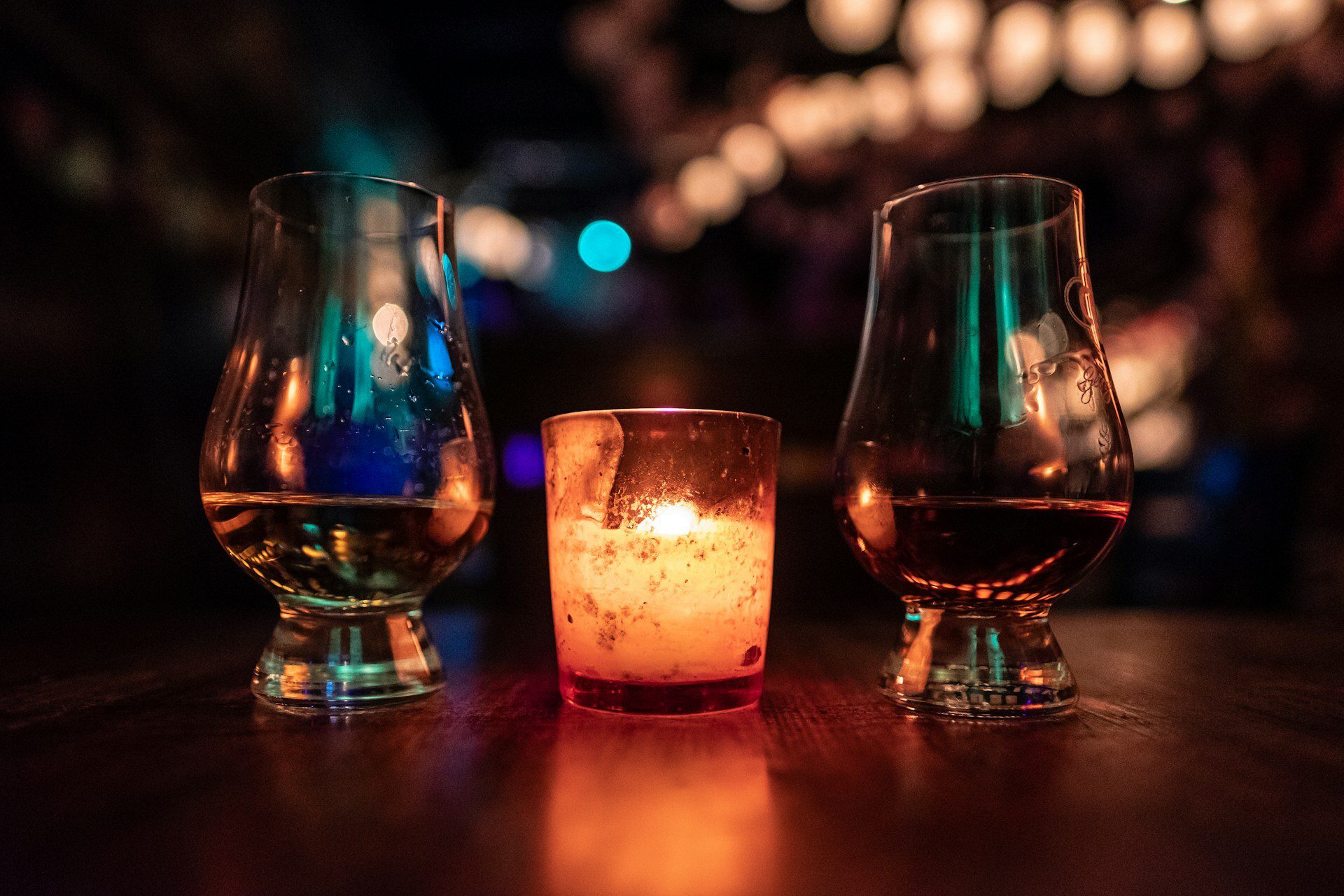 Two whisky glasses with a candle
